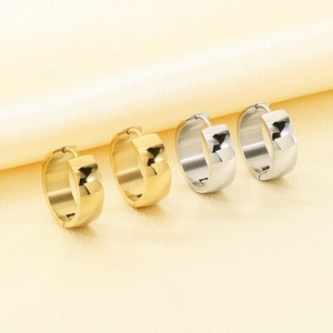 Detailed macro view of polished gold and silver stainless steel wide hoop earrings