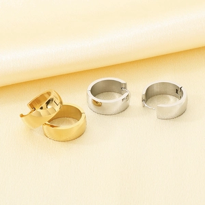 Close-up of minimalist stainless steel hoop earrings with polished gold and silver finish