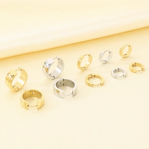 Detailed view of various sizes of polished stainless steel hoop earrings in gold and silver