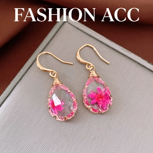 Elegant water-drop resin earrings featuring dried pink flowers and handcrafted gold hooks