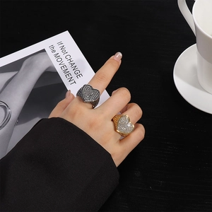 Primer plano de anillos de corazón de acero inoxidable con brillantes pedrería dedos
