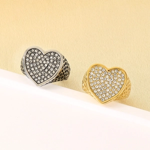 Detalle de anillos en forma de corazón de plata y oro con pavé completo de diamantes