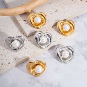 Elegantes pendientes de corazón con perla irregular en oro y plata sobre piedra