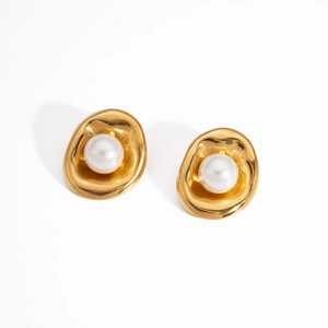 Primer plano de pendientes irregulares de acero inoxidable dorado con perla blanca central.