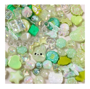 Dettaglio di perline in resina verde a forma di stella, cuore e coniglio per gioielli fai da te
