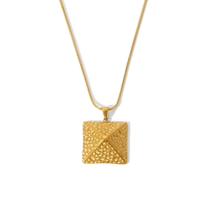 Nahaufnahme einer goldenen Edelstahlkette mit einem geprägten Pyramidenanhänger.