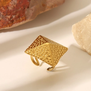 Detailansicht eines vergoldeten Edelstahlrings in Pyramidenform mit Hammerschlag-Textur