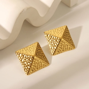 Nahaufnahme von goldenen Edelstahl-Ohrsteckern in Pyramidenform mit Hammerschlag-Struktur