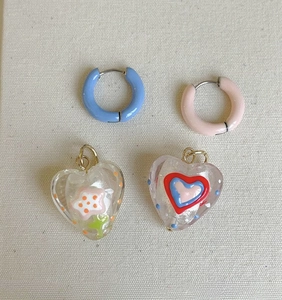 Detailansicht der Vintage-Ohrringe in Hellblau und Rosa mit herzförmigen Anhängern.