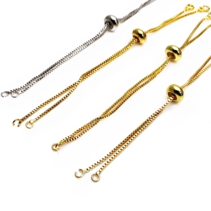 Dettaglio di catene regolabili con perle scorrevoli in oro e argento per bracciali