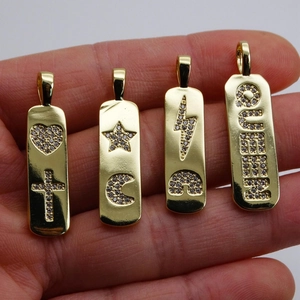 Quatre pendentifs rectangulaires dorés avec zircons, motifs cœur, étoile, lune et QUEEN