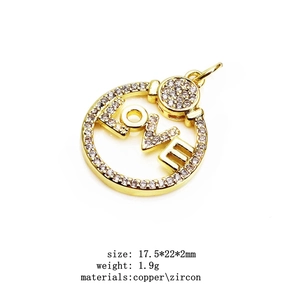 Detailed macro view of a round gold-plated LOVE pendant with micro-pave cubic zirconia