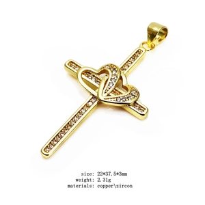 Macro detail of a gold-plated copper cross pendant with heart center and zircon inlays