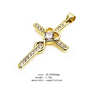 Macro shot of 19.5x32mm gold plated copper heart cross pendant with cubic zirconia stones