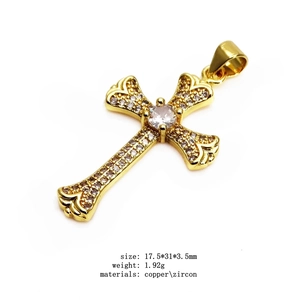 Macro detail of a 17.5x31mm gold-plated copper cross pendant with white zircon stones