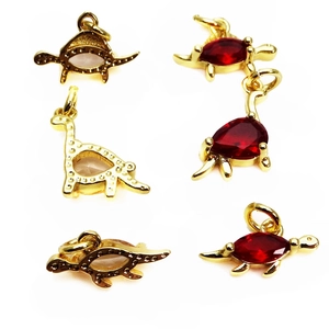 Golden dinosaur and sea creature charms with red and pink cubic zirconia stones