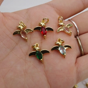 Detailed view of five colorful dinosaur charms with sparkling marquise zircons in a palm