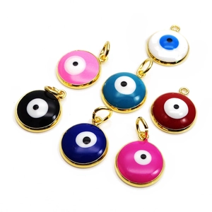 Detailed view of colorful enamel evil eye charms with golden metal frames and rings