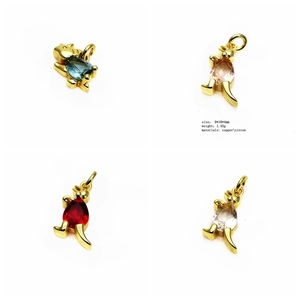 Macro detail of dinosaur charms with colorful cubic zirconia in gold-plated copper