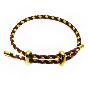 Close-up of black, yellow, and red braided rope bracelet with gold metal slider buckles