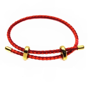 Detail of red braided fiber bracelet showing the double-strand spiral texture and gold clasp