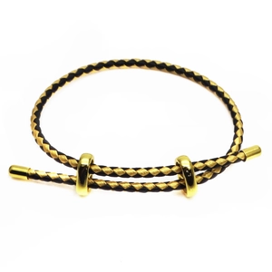 Detail of adjustable 3mm black and gold woven cord bracelet with metallic sliding clasps