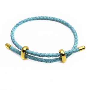 Detail of light blue braided leather bracelet with adjustable gold sliding metal clasps