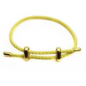 Detail of lemon yellow braided leather cord bracelet with adjustable gold sliding beads