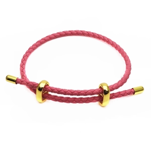 Detail of pink braided bracelet with two adjustable polished gold metal slide buckles