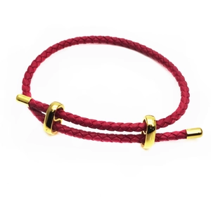 Detail of dark red woven cord bracelet with adjustable gold sliding metal rings