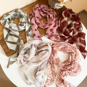 Detailed view of assorted mesh chiffon scarves with floral and checkered patterns