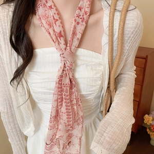 Detail of a pink floral mesh scarf styled as a stylish necktie accessory for women