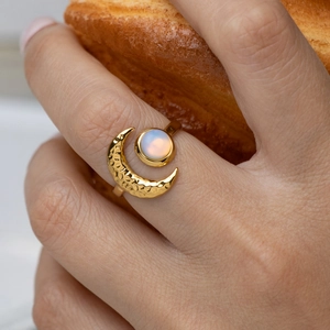 Close-up of a 18K gold-plated stainless steel moon ring with an iridescent stone.