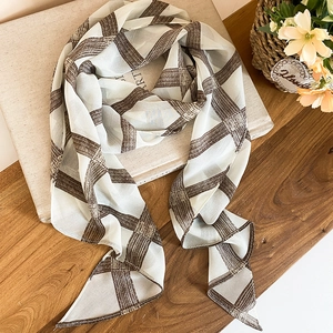 Close-up detail of lightweight brown plaid mesh silk scarf for women's neck accessory