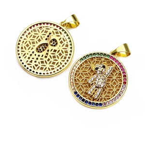 Close-up of golden hollow pendants with micro-paved rainbow cubic zirconia stones