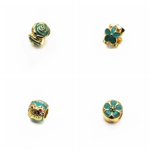 Détail macro de perles de fleurs en émail vert et blanc avec des breloques dorées