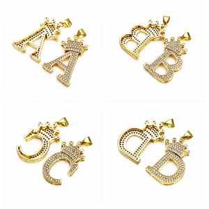 Detailed macro view of gold-plated crown alphabet pendants with micro-pave cubic zirconia