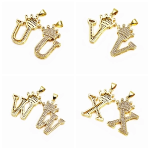Macro shot of gold-plated crown alphabet pendants U V W X with pavé cubic zirconia