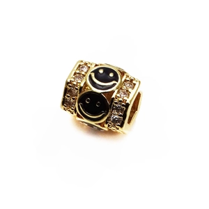 Macro detail of 14K gold plated barrel bead with smiley face and crystal pavé setting