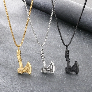 Close-up of three Viking battle axe pendants in gold, silver, and black finish.