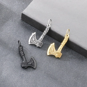 Detailed view of Nordic Viking war axe pendants in gold, black, and silver finishes