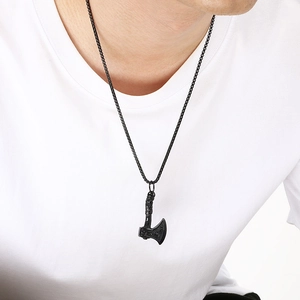 Detailed macro view of the black Viking battle axe pendant necklace on a male model