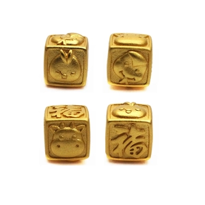Macro shot of gold square beads with Chinese Fu character and zodiac animal carvings