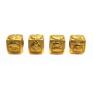 Macro shot of gold cube beads with embossed animal patterns and matte finish