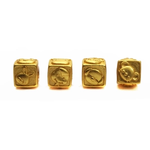 Detailed macro view of four gold-plated cubic zodiac beads with relief pet patterns
