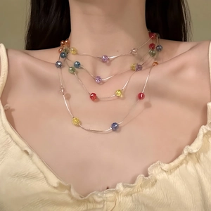 Gros plan sur un collier de perles colorées multicouches style dopamine sur modèle