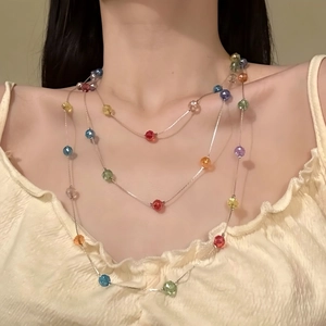 Détail d'un collier de perles colorées multi-rangs sur un cou de femme