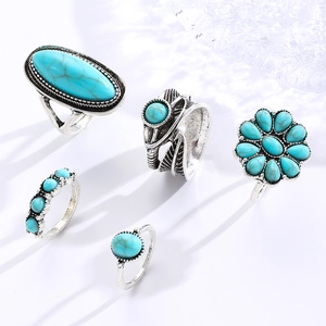 Close-up of vintage bohemian turquoise ring set featuring leaf and flower designs