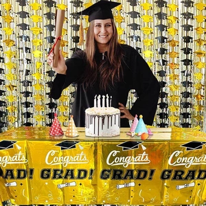 Detail of gold graduation tablecloth with Congrats Grad print and matching party decorations