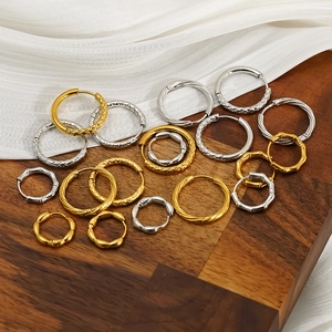 Close-up of stainless steel hoop earrings with bamboo and mesh textures in gold and silver